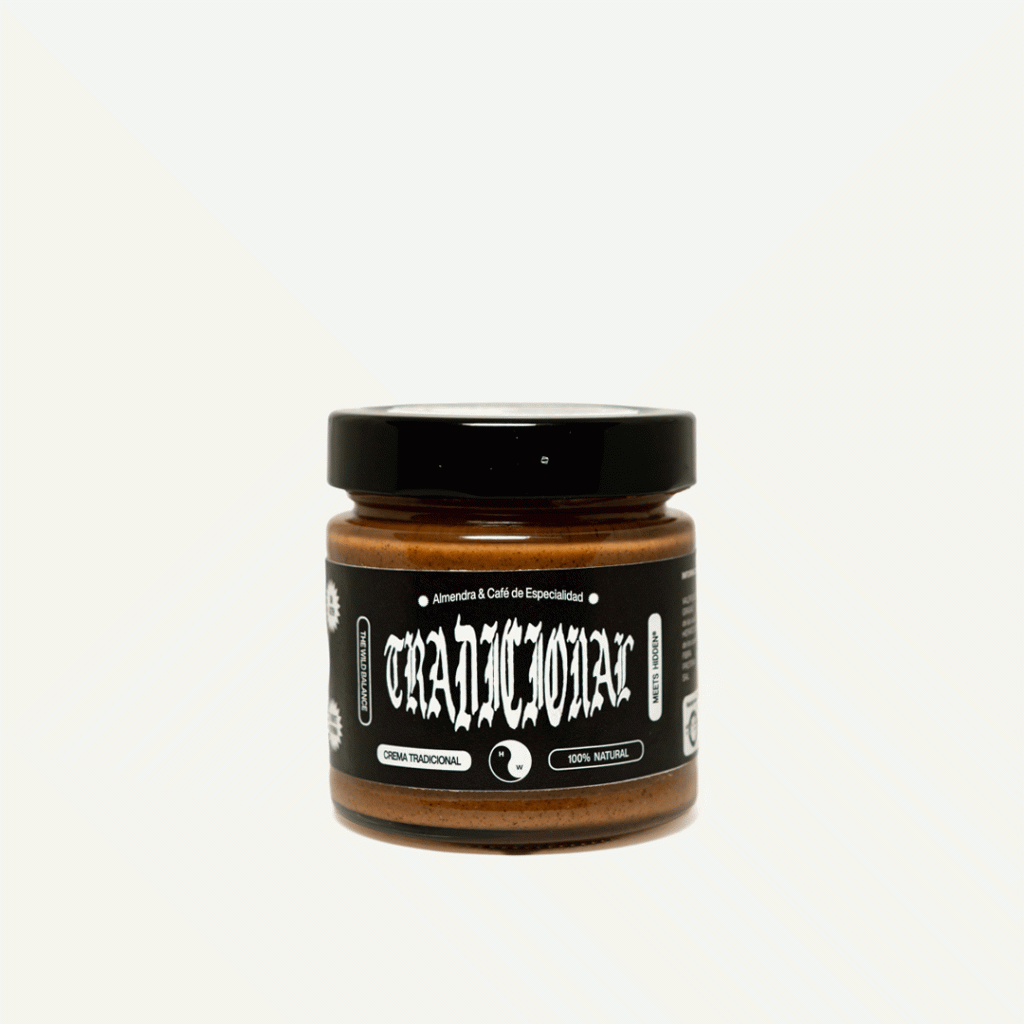 Bote de cristal con crema de almendras y café de especialidad Tradicional de Hidden Coffee Roasters y The Wild Balance, con tapa negra y etiqueta negra con tipografía gótica, sobre fondo negro