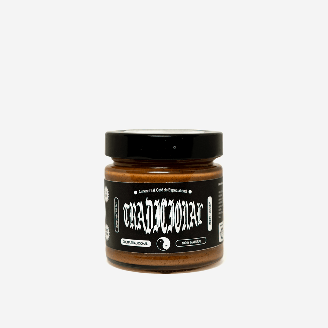 Bote de cristal con crema de almendras y café de especialidad Tradicional de Hidden Coffee Roasters y The Wild Balance, con tapa negra y etiqueta negra con tipografía gótica, sobre fondo negro